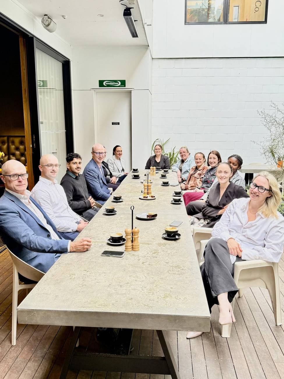 A group around the long table in the Heritage Coffee courtyard