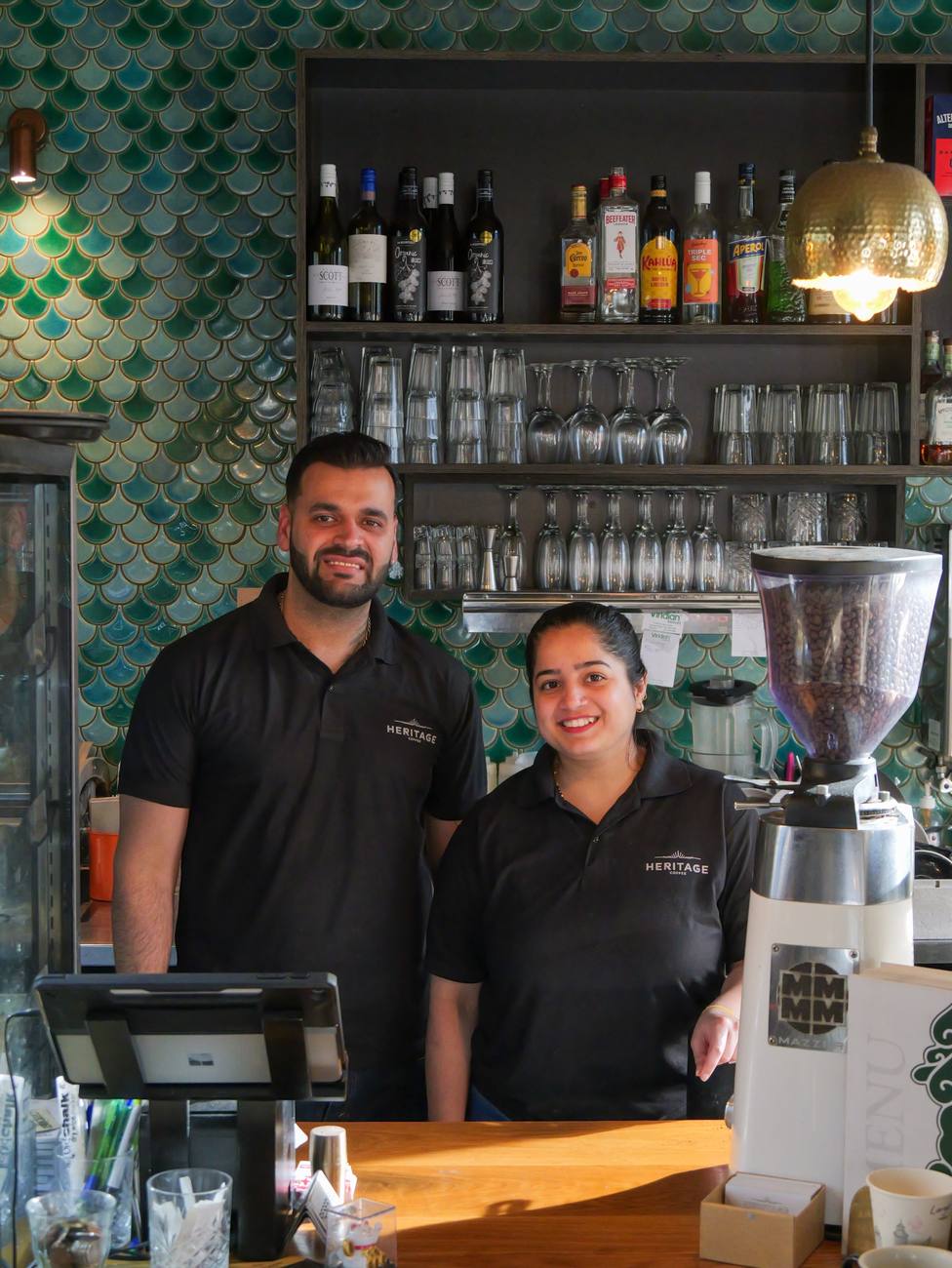 Two of the Heritage Coffee team smiling behind the bar